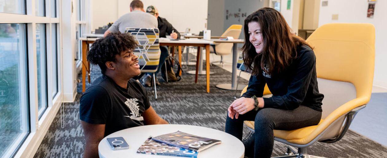 Two trinity college students conversing in a study lounge