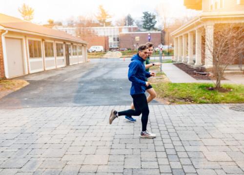 Trinity college student athletes running through campus